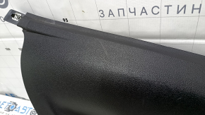 Крупный план накладки задней стойки, виден царапины и следы использования на поверхности детали.