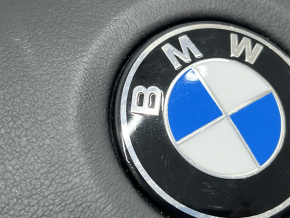Чёткий фрагмент эмблемы BMW, установленной на подушке безопасности руля.