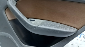 Крупный план обшивки двери Audi Q3, видно состояние ручки и повреждения.