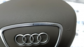 Часть хромированной накладки на подушке безопасности Audi Q5 с потертостями.