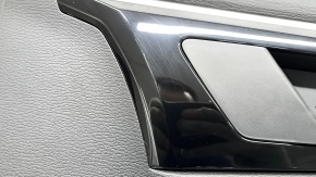 Крупный план молдинга над обшивкой двери Mitsubishi Outlander, видно потертости на черном глянце