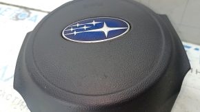 Крупный план лицевой части подушки руля Subaru с логотипом, имеются следы износа