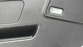 Вид на боковую часть обшивки двери багажника Audi Q3 2019-2025, видно наличие следов эксплуатации.