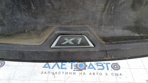 Крупный план логотипа X1 на резиновом коврике багажника BMW