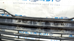 Вид на нижнюю решетку бампера Toyota Camry с не заводскими отверстиями и повреждениями креплений.