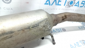 Крупный план приемной трубы с катализатором, видимые повреждения на поверхности.