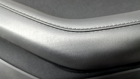 Крупный план угла подлокотника обшивки двери Mazda CX-30, замечены следы использования.