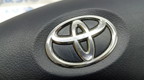 Крупный план логотипа Toyota на подушке безопасности руля.
