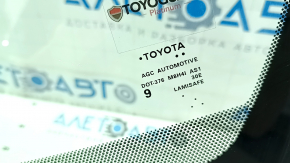 Маркировка на лобовом стекле Toyota, указывающая на оригинальность и спецификации детали