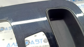 Крупный план накладки центральной консоли Mercedes W167, деталь черного глянца с небольшими потертостями.
