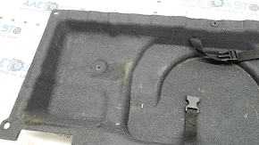 Крупный план покрытия пола багажника BMW X5 F15 с дефектами, вид слева.