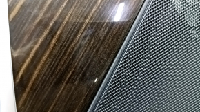 Деталь вставки под дерево на обшивке двери BMW X5 G05 рядом с сеткой динамика.