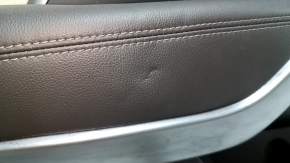 Крупный план вмятины на кожаном подлокотнике двери Hyundai Santa Fe Sport.