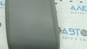 Крупный план поверхности подлокотника Audi Q5, серого цвета, с вмятиной.