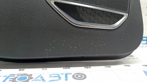 Крупный план нижней части обшивки задней двери Audi Q3 с заметными потертостями.