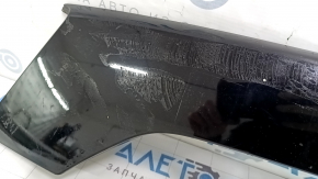 Крупный план повреждений на молдинге двери багажника Ford Escape, наличие клея на задней стороне.