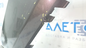 Деталь крепления на бампере Audi Q3 с видимыми повреждениями и сколами.