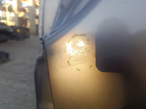 Мелкие дефекты на бежевой четверти Chrysler Pacifica, световые отражения.