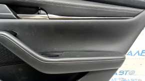 Что-то видно на верхней части обшивки двери Mazda 3 2019-2026, требуется чистка.