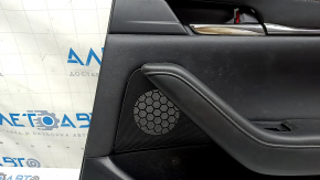 Крупный план над динамиком на задней правой двери Mazda 3, незначительные следы использования.