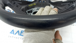 Крупный план покрытия руля Mercedes W213, показывающий износ и царапины.
