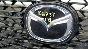 Детали эмблемы на решетке радиатора Mazda 3 2019; вид сбоку, низкие потертости.