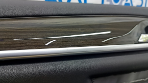 Детальный крупный план молдинга под дерево на двери BMW 5 G30, видны царапины.