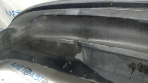 Деталь бампера Ford Fusion, в фокусе повреждения на поверхности, видно место примятия.