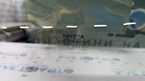 Ближайший крупный план на маркировку стекла Toyota, видно круг дипломированного градусника.