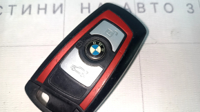 Ключ BMW 3 F30 в крупном плане, отображает логотип, имеются царапины.