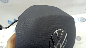 Нижний ракурс подушки безопасности Volkswagen, видно некоторые царапины на черной поверхности.