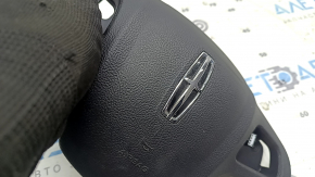 Ручное обследование руля со значком Lincoln MKC, видно его качество и оригинальность.