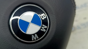 Еще один крупный план эмблемы BMW на подушке безопасности, проявляется микроповреждение.