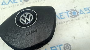 Вид на логотип Volkswagen и текст 'AIRBAG' на подушке безопасности руля, состояние в целом хорошее.