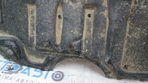 Крупный план повреждения на защите двигателя Toyota Camry, замечены надрывы.