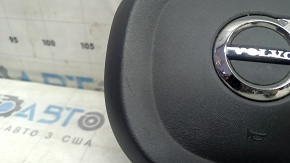Крупный план логотипа Volvo на подушке, показывающий состояние детали.