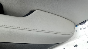 Крупный план обшивки двери Honda CR-V с акцентом на швы и отделку из серой кожи.