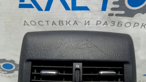 Крупный план повреждений на накладке центральной консоли, заметные царапины.