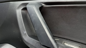 Ручка на обшивке двери Volkswagen Tiguan, здесь видно состояние пластика и признаки износа.