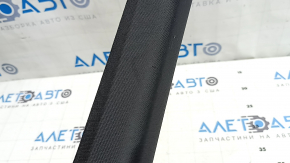 Крупный план повреждений на накладке передней стойки, присутствуют потертости и надрыв.
