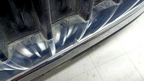 Крупный план повреждений на хромированной поверхности решётки BMW 5, царапины и вздутия.