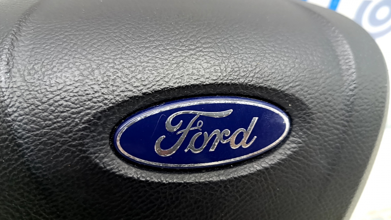 Крупный план подушки безопасности Ford с видимым дефектом в виде царапины.