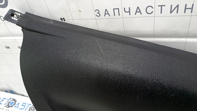 Крупный план накладки задней стойки, виден царапины и следы использования на поверхности детали.