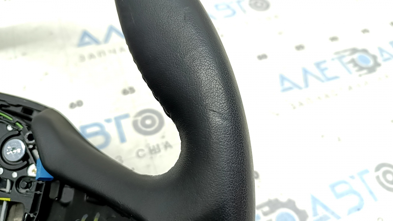 Крупный план ручки руля BMW X5 G05 с легкими следами эксплуатации.
