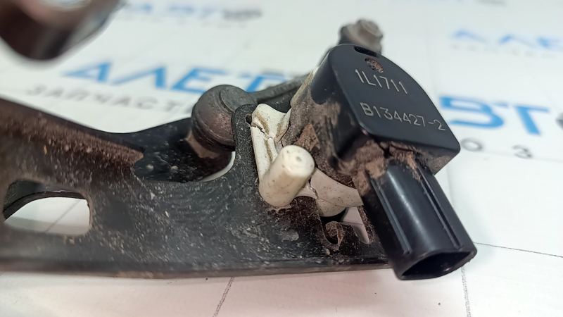 Деталь датчика положения кузова заднего бампера Toyota Prius 50 16-22 с следами эксплуатации на крепежных элементах.