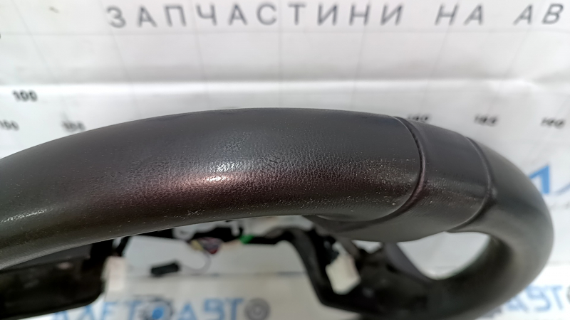 Деталь рулевого колеса Acura с близкого ракурса, видны дефекты на поверхности.