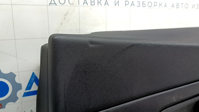 Детальный обзор повреждений на обшивке двери, вид сверху: царапины и примятости.