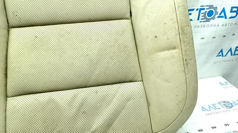 Угол заднего ряда сидений Lexus ES300h 2013-2014 года, вид на пораженную кожаную обивку с дефектами.