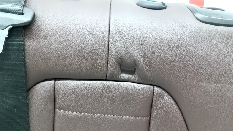 Дефект на кожаной обивке заднего сидения BMW X3 G01 2018-2023, вид крупным планом.