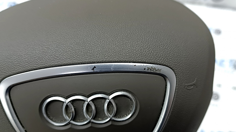 Часть хромированной накладки на подушке безопасности Audi Q5 с потертостями.